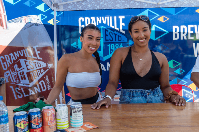 people on the beach posing for a photo in the granville stand